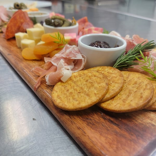 Martiniz Fresko Kitchen's charcuterie board with meats, cheeses, dried apricots, crackers, and dips.