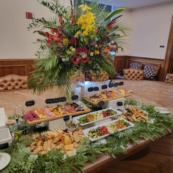 Martiniz Fresko Kitchen's brunch spread with charcuterie boards, roasted vegetables, and crackers on a long table.