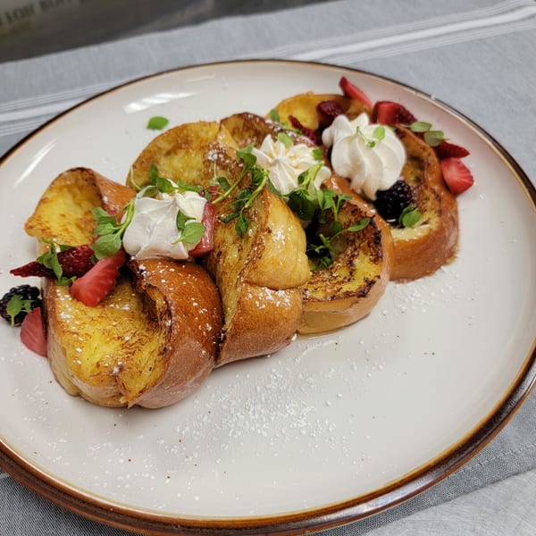 Martiniz Fresko Kitchen's French toast with whipped cream, fresh berries, and powdered sugar.
