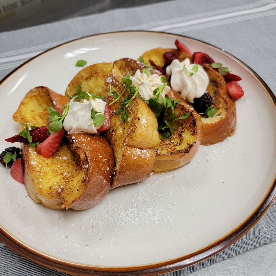 Martiniz Fresko Kitchen's French toast with whipped cream, fresh berries, and powdered sugar.